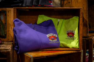 Folded purple and green Hooper's zipper hoodies